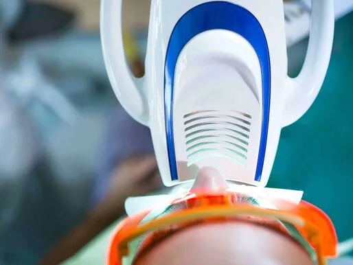 Bleaching-Lampe über den Zähnen einer Patientin