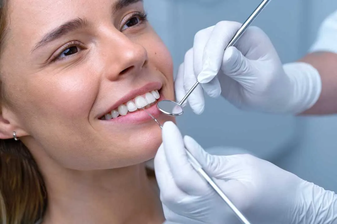 Dentalhygienikerin behandelt eine Patientin auf dem Behandlungsstuhl