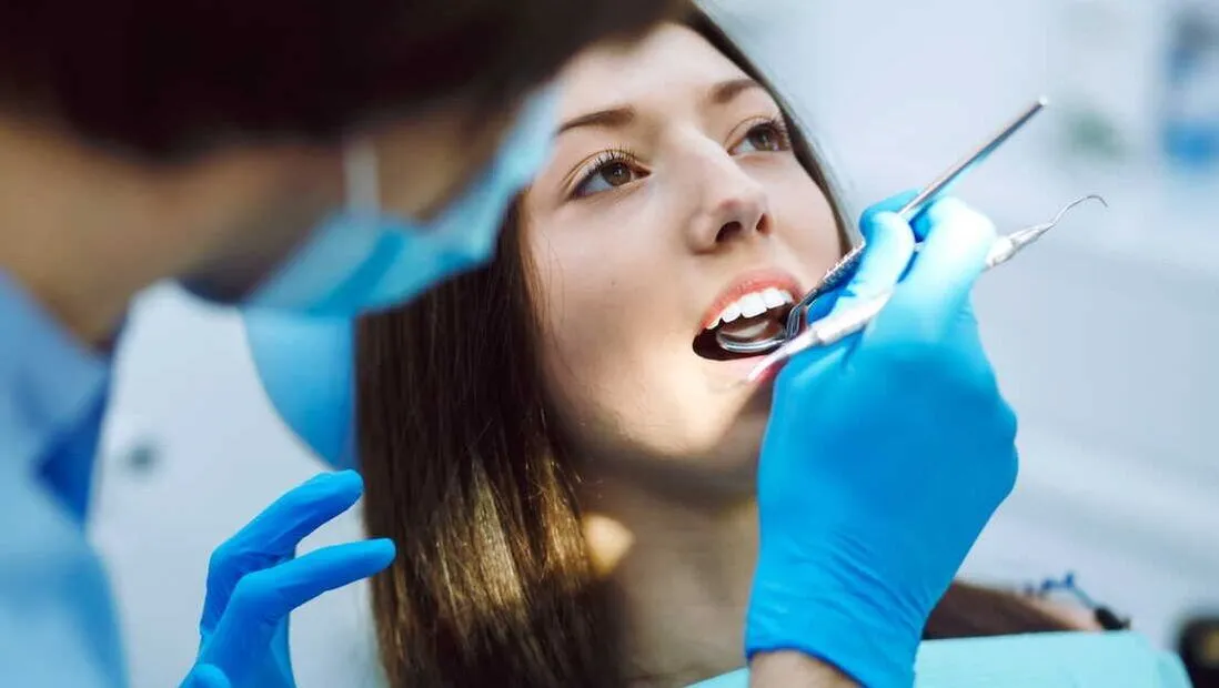 Dentalhygienikerin kontrolliert Zahnfleisch und Zähne