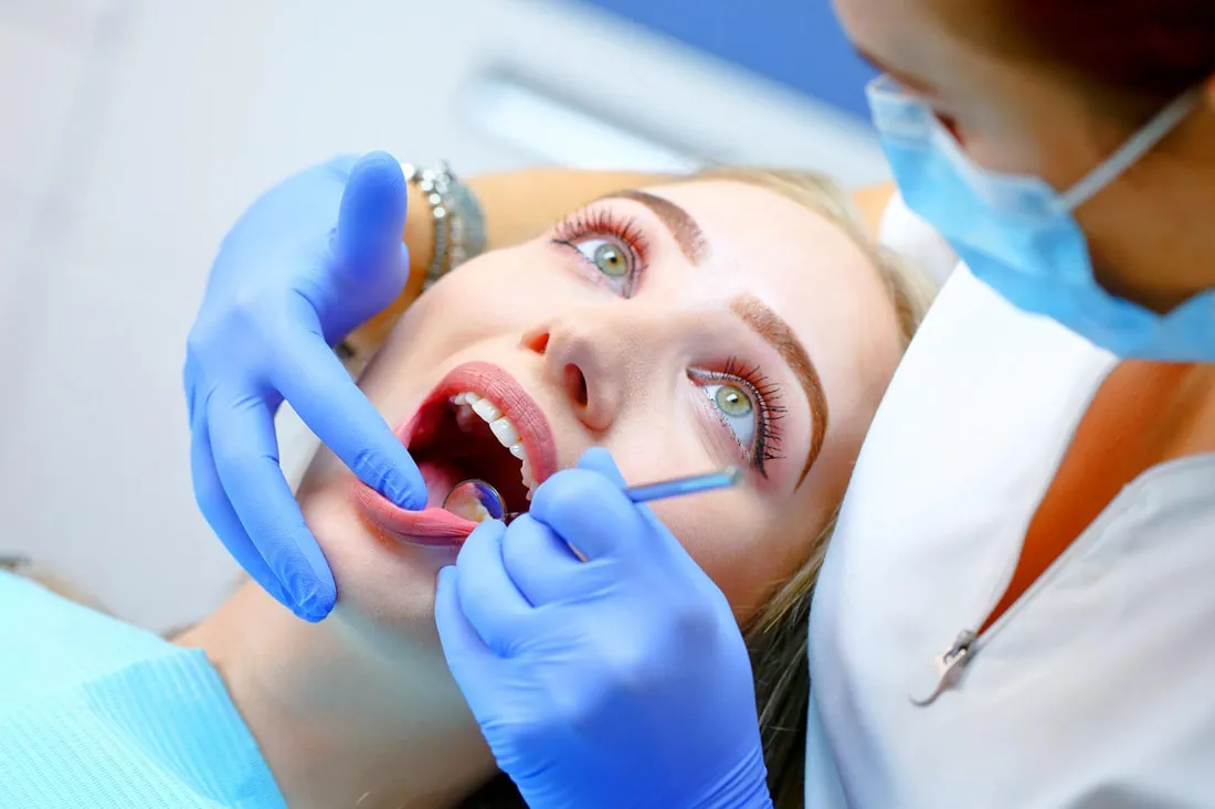 Dentalhygienikerin behandelt eine Patientin