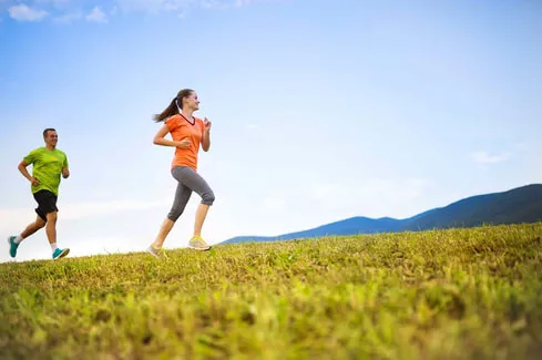 Frau joggt über eine Wiese